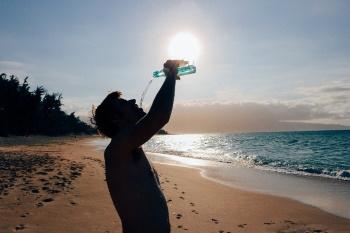 Man drinkt water op het strand